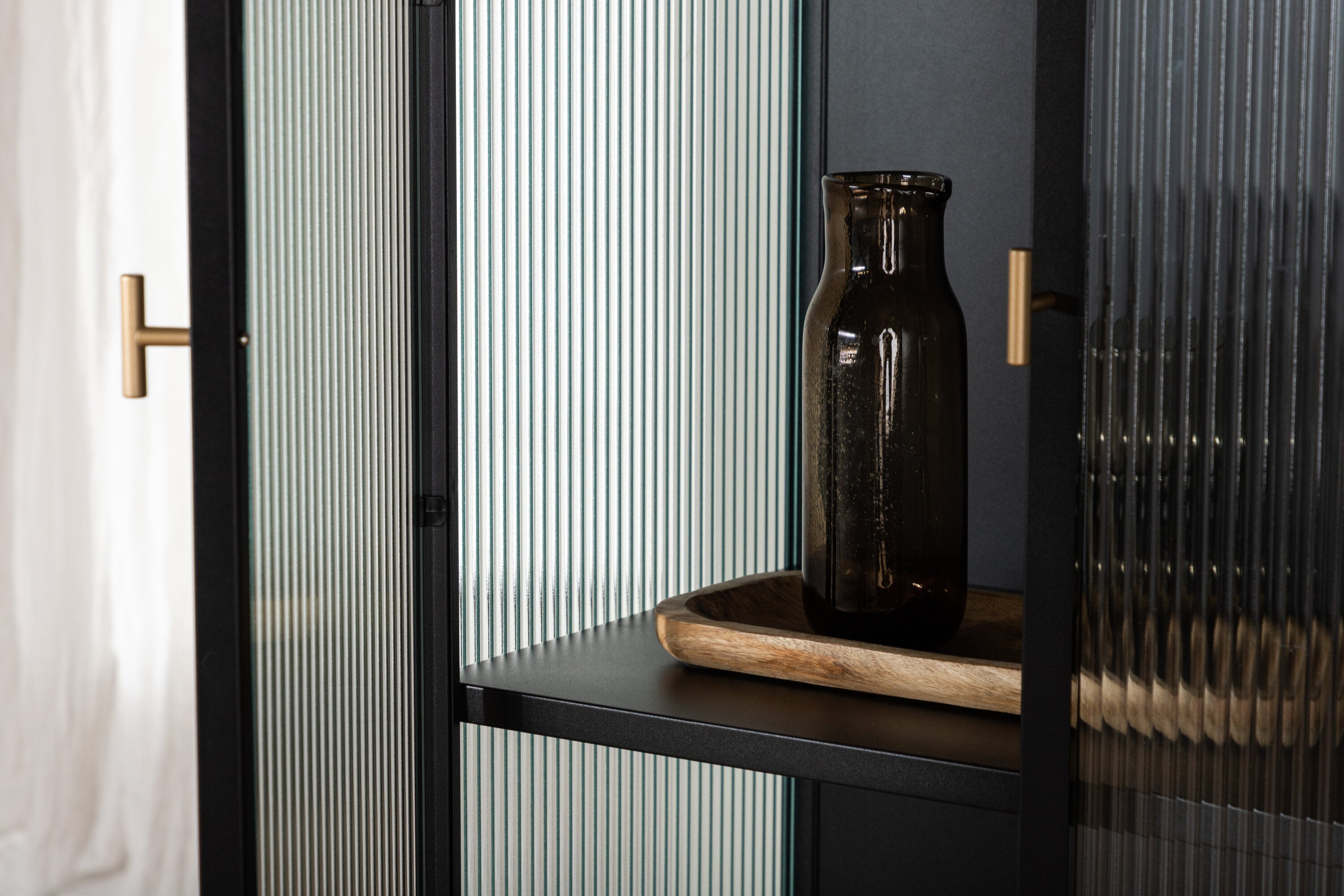 Vitrine Leonie - in Schwarz mit Wellenglas-Optik